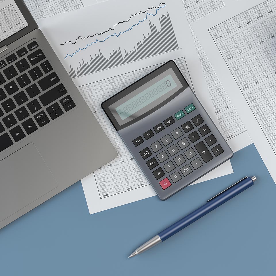 flat lay of a calculator, part of a laptop computer, a pen, and some printed charts